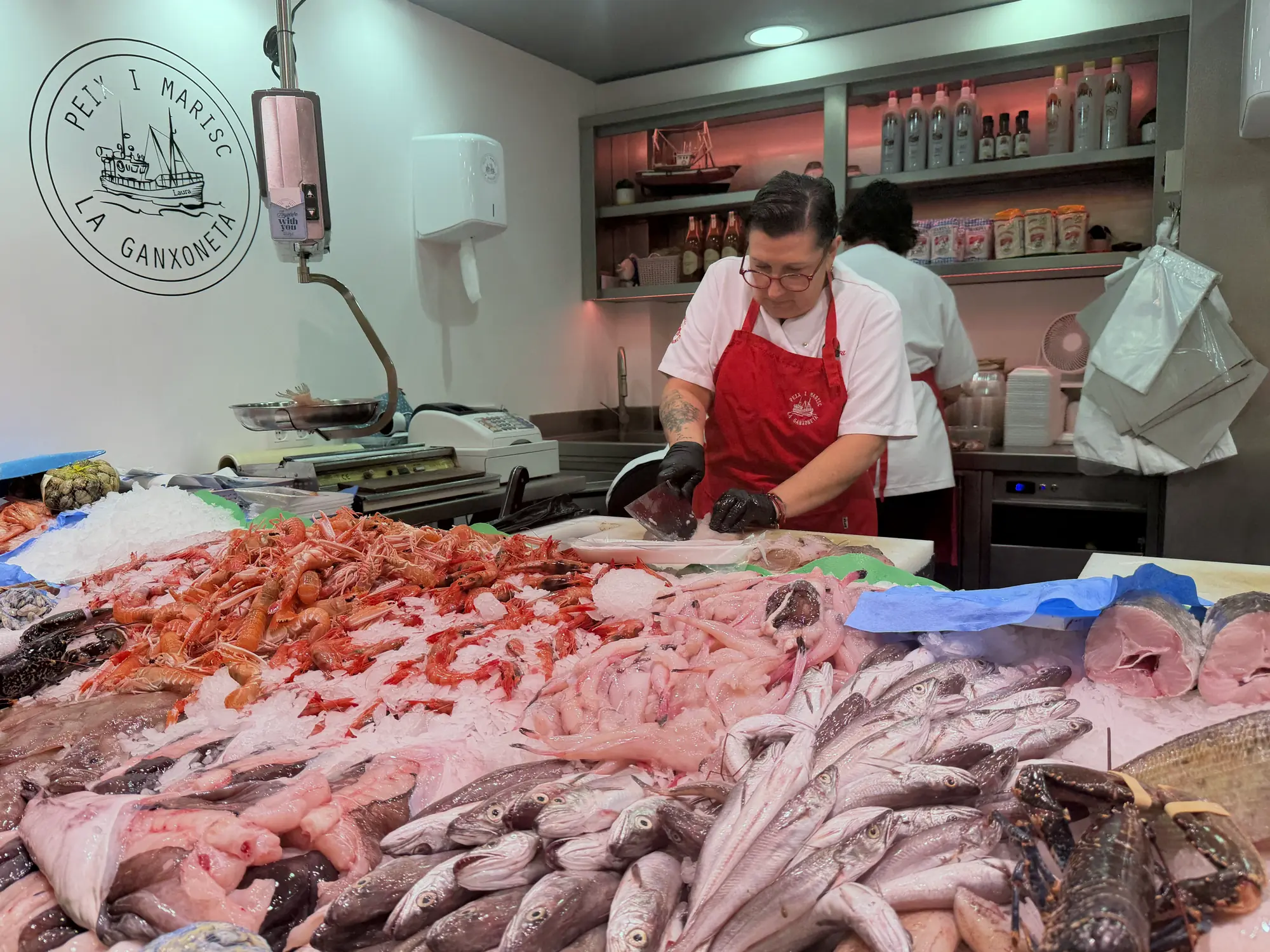 La parada de La Ganxoneta al Mercat Municipal, amb el rètol rodó de la barca a la paret.